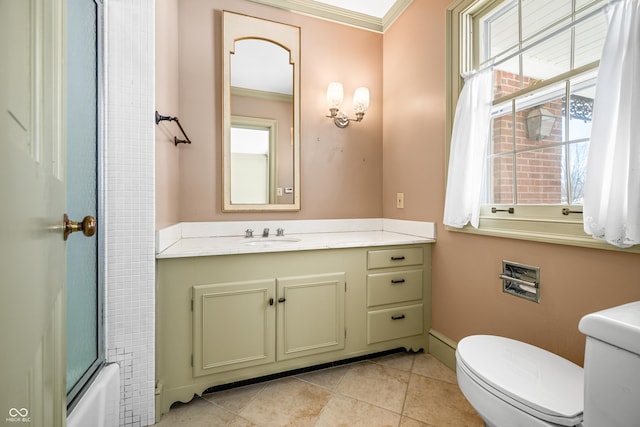 full bathroom with tile patterned floors, crown molding, bath / shower combo with glass door, toilet, and vanity