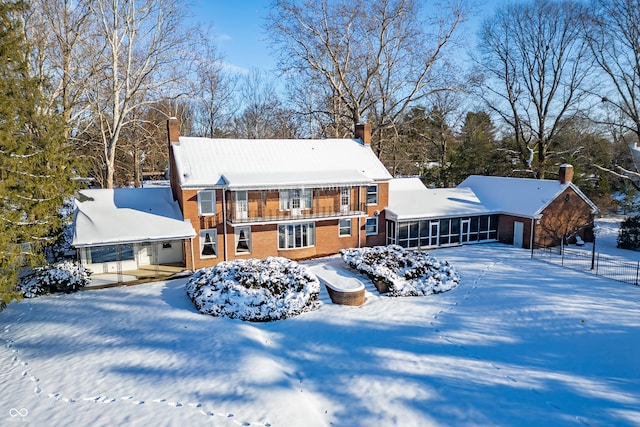 snow covered property featuring a sunroom