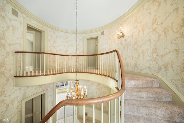 stairway featuring a notable chandelier and ornamental molding