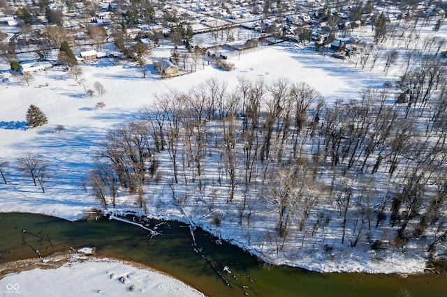 snowy aerial view with a water view