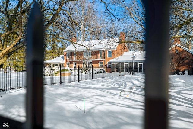 snow covered property with a sunroom