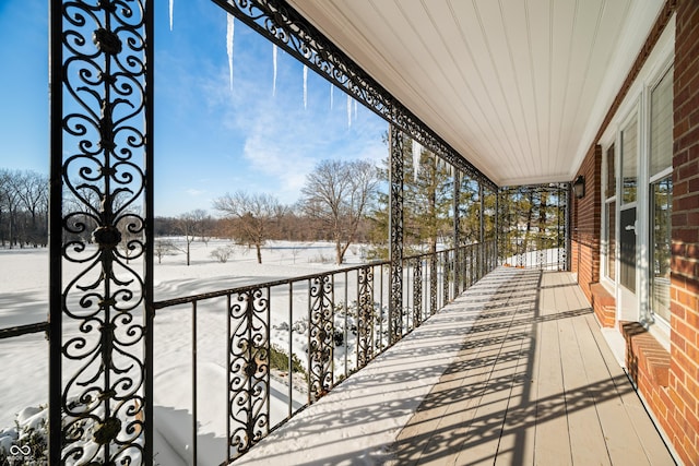 view of snow covered back of property