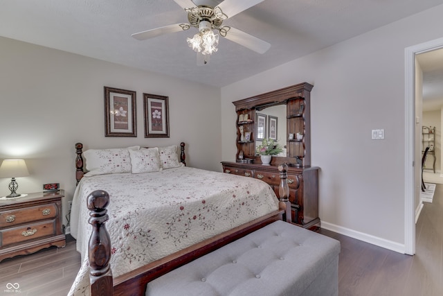 bedroom with dark hardwood / wood-style flooring and ceiling fan