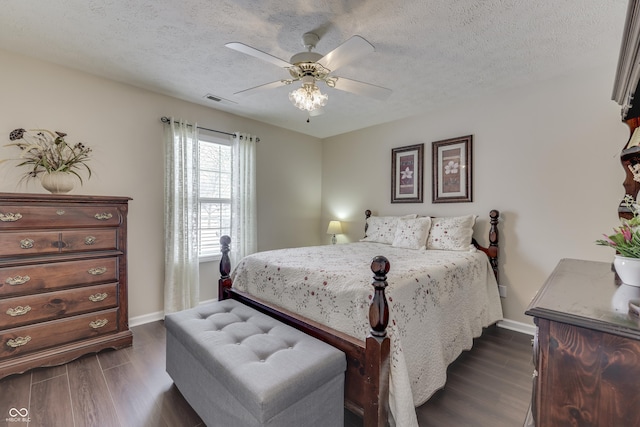 bedroom with a textured ceiling, dark hardwood / wood-style flooring, and ceiling fan