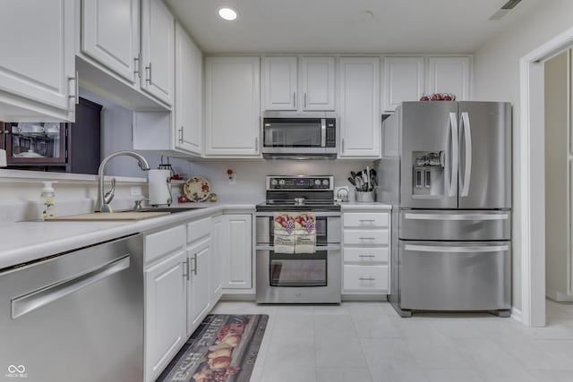 kitchen featuring light tile patterned flooring, sink, white cabinets, and stainless steel appliances