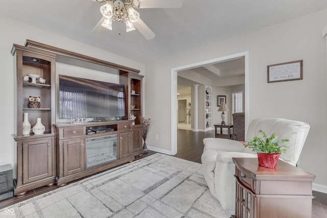 living room with hardwood / wood-style flooring, ceiling fan, and decorative columns