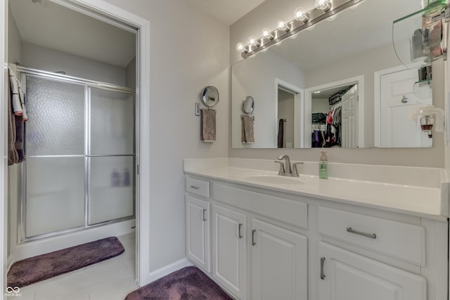 bathroom featuring tile patterned flooring, vanity, and walk in shower