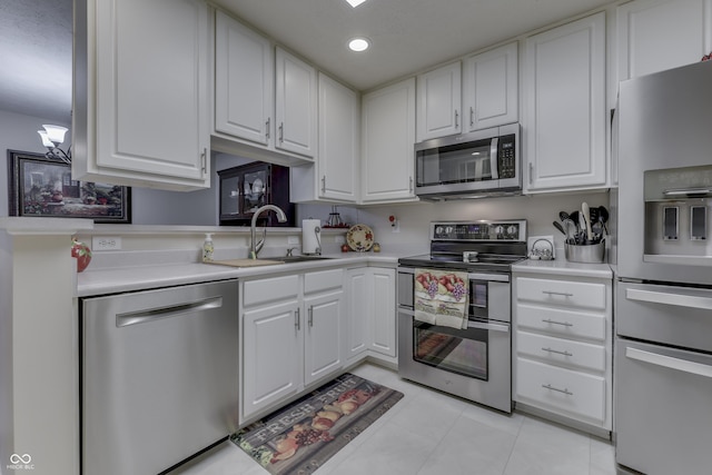 kitchen with white cabinets, light tile patterned floors, stainless steel appliances, and sink