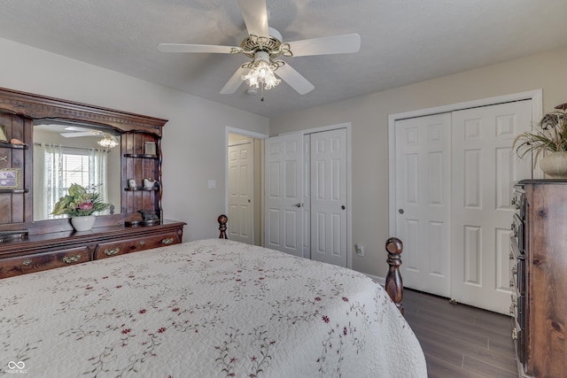 bedroom featuring ceiling fan, dark wood-type flooring, and two closets