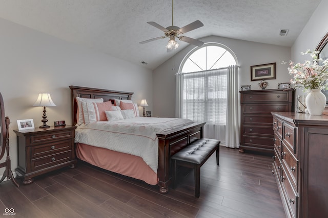 bedroom with a textured ceiling, vaulted ceiling, and ceiling fan