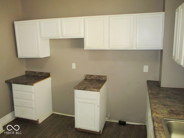 1138 W 33rd St, Indianapolis, IN 46208 - kitchen with dark wood-style flooring, baseboards, and white cabinets