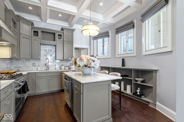 kitchen featuring backsplash, dark wood-type flooring, sink, decorative light fixtures, and double oven range