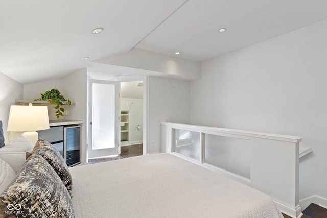 bedroom with carpet, vaulted ceiling, and beverage cooler