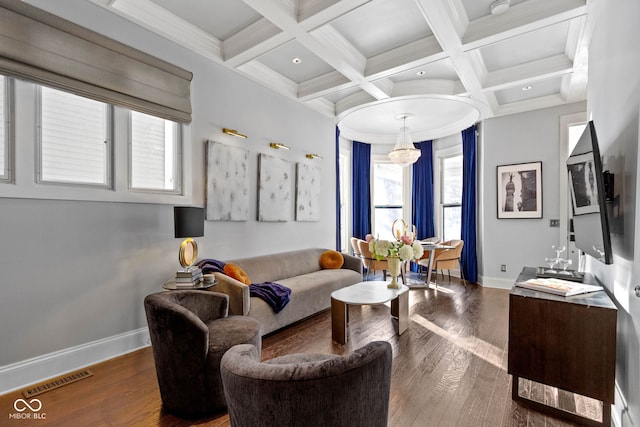 living room with beamed ceiling, wood-type flooring, coffered ceiling, and a notable chandelier