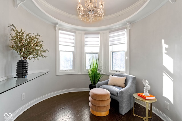 living area featuring a raised ceiling, crown molding, wood-type flooring, and a notable chandelier