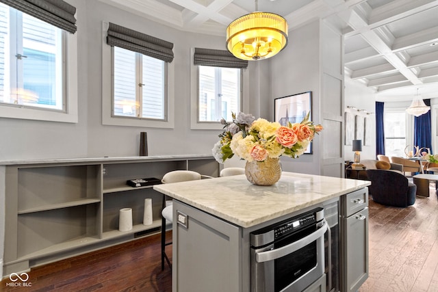 kitchen featuring a breakfast bar, stainless steel oven, beam ceiling, and coffered ceiling