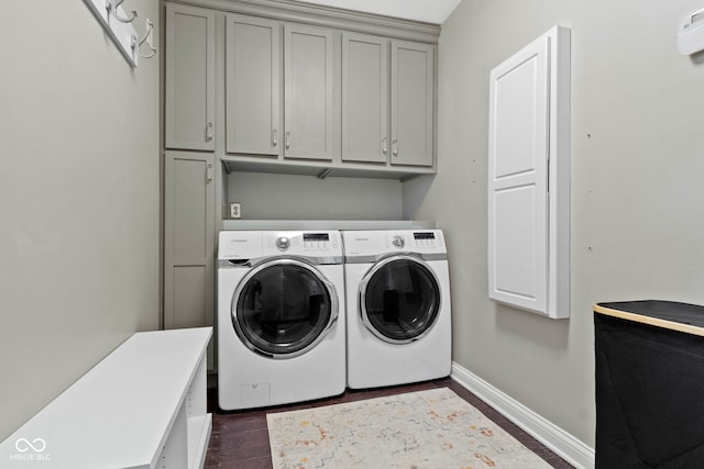 laundry room featuring cabinets, washing machine and dryer, and dark hardwood / wood-style floors