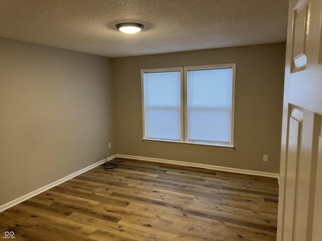 unfurnished room featuring hardwood / wood-style flooring and a textured ceiling