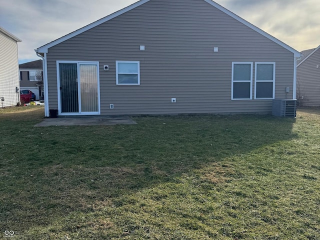 rear view of house featuring cooling unit and a yard