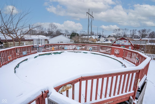 snow covered deck featuring a storage unit