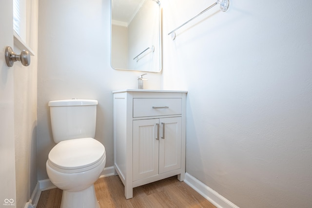 bathroom featuring crown molding, hardwood / wood-style floors, vanity, and toilet