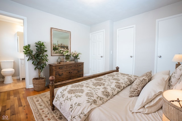 bedroom with hardwood / wood-style flooring and ensuite bath