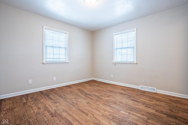 spare room with hardwood / wood-style flooring and plenty of natural light