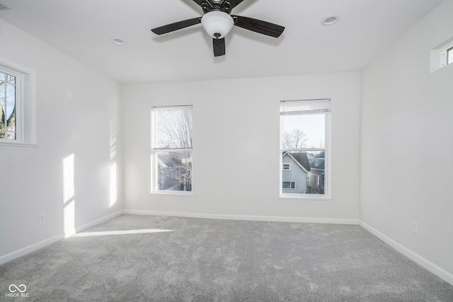 carpeted empty room with ceiling fan and a healthy amount of sunlight