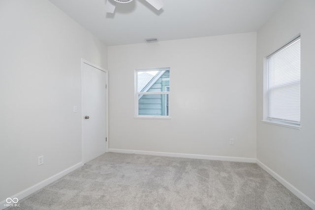 spare room featuring ceiling fan and light colored carpet