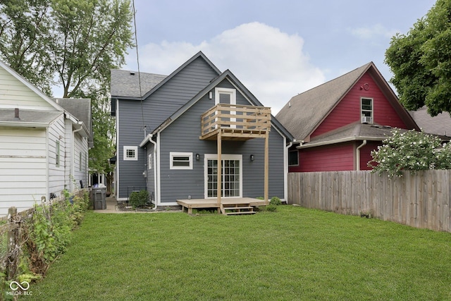 back of house featuring a yard, a balcony, and a wooden deck