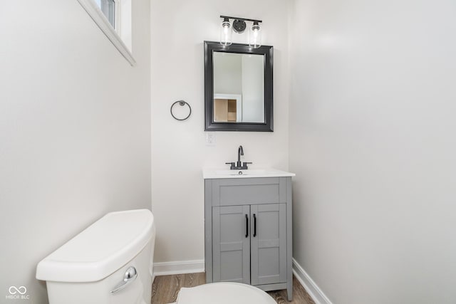 bathroom featuring vanity, hardwood / wood-style flooring, and toilet