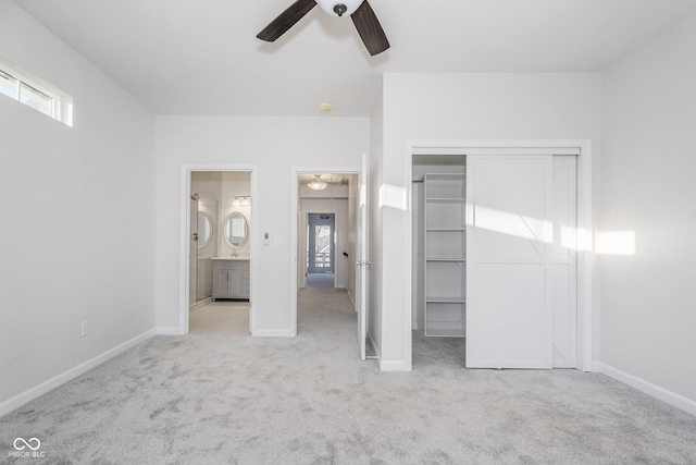 unfurnished bedroom featuring light carpet, a closet, ceiling fan, and ensuite bathroom