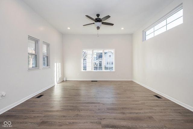 empty room with ceiling fan and dark hardwood / wood-style flooring