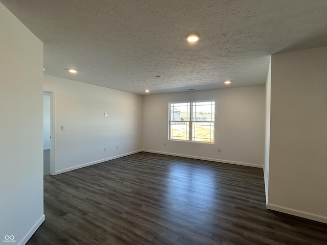 unfurnished room with dark wood-type flooring and a textured ceiling