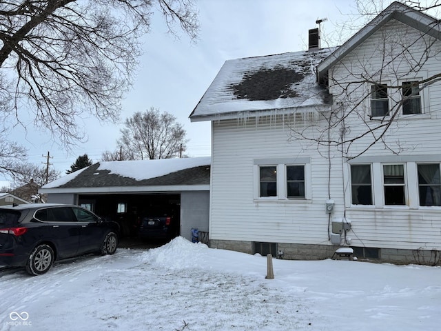 view of snow covered exterior featuring a garage