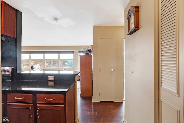 kitchen featuring dark hardwood / wood-style flooring and dark stone counters