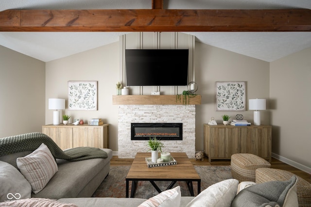 living room featuring hardwood / wood-style flooring, vaulted ceiling, and a stone fireplace