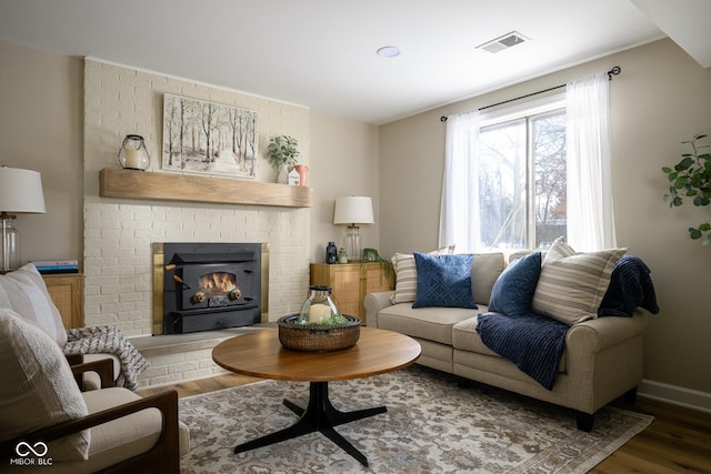 living room featuring dark wood-type flooring and a fireplace