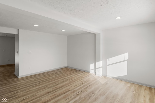 unfurnished room with wood-type flooring and a textured ceiling