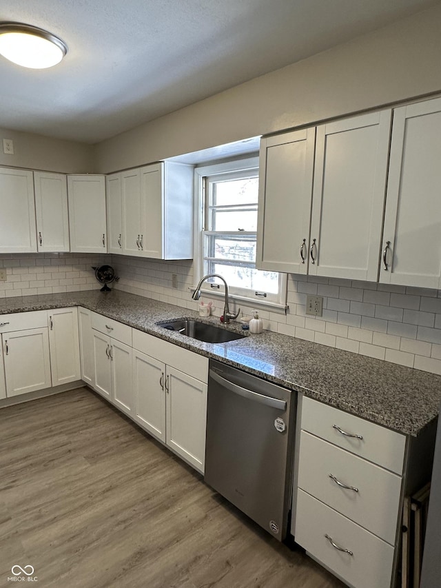 kitchen featuring decorative backsplash, sink, light hardwood / wood-style flooring, dishwasher, and white cabinetry