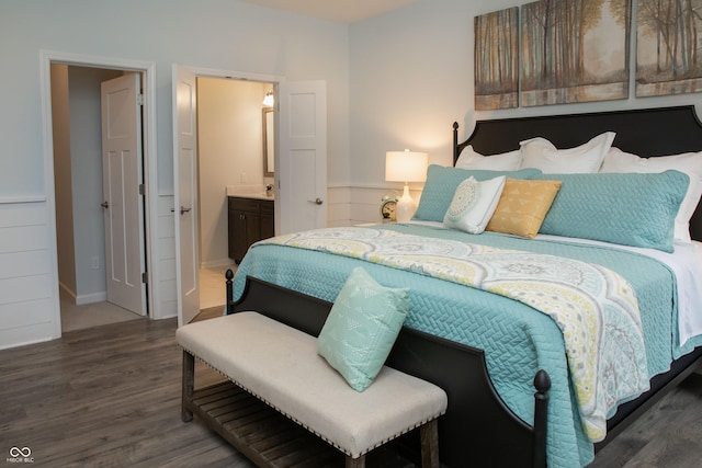 bedroom featuring ensuite bath and dark hardwood / wood-style floors