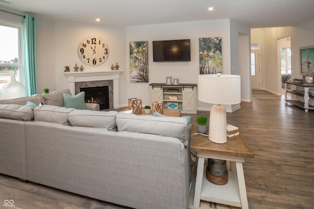 living room with a high end fireplace and dark hardwood / wood-style flooring