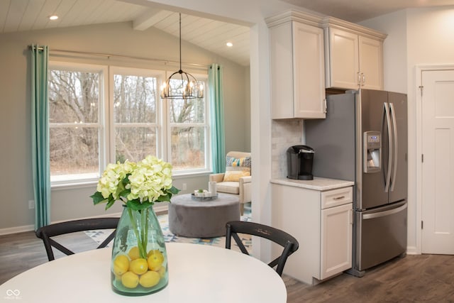 kitchen with hanging light fixtures, stainless steel fridge with ice dispenser, lofted ceiling with beams, dark hardwood / wood-style floors, and decorative backsplash