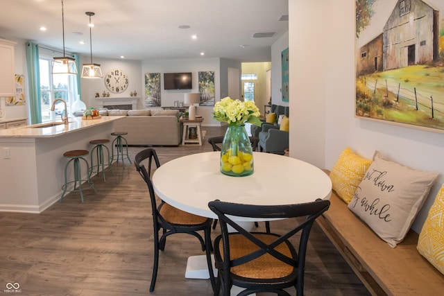 dining space with dark hardwood / wood-style floors and sink