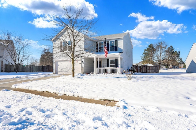 snow covered back of property featuring a porch and a garage