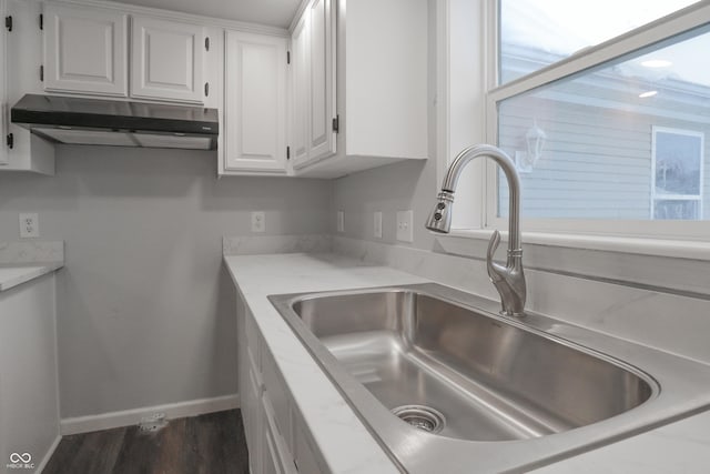 kitchen with dark hardwood / wood-style floors, sink, and white cabinets