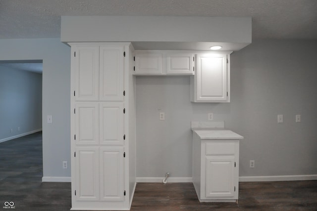 washroom with dark hardwood / wood-style floors and a textured ceiling