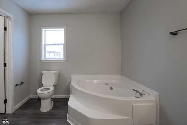 bathroom featuring wood-type flooring, a washtub, and toilet