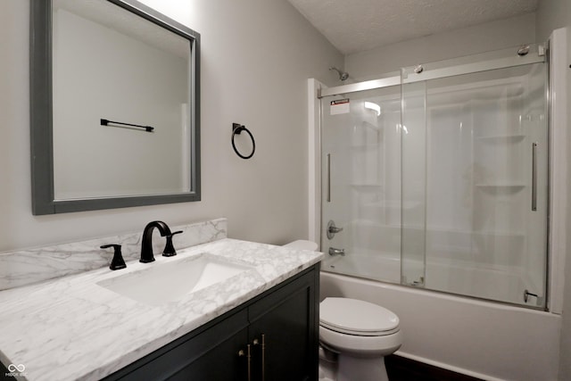 full bathroom with vanity, toilet, combined bath / shower with glass door, and a textured ceiling