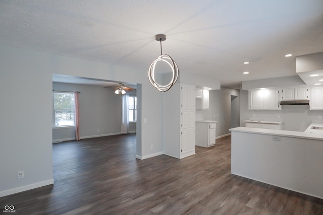 kitchen featuring ceiling fan, a textured ceiling, white cabinets, dark hardwood / wood-style flooring, and decorative light fixtures